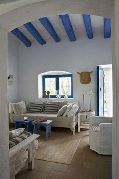 an open living room with blue and white decor on the walls, couches and coffee table