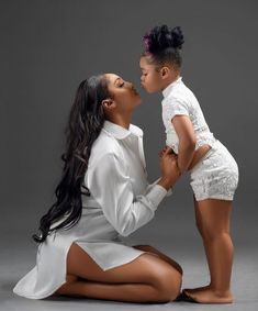 a woman kneeling down next to a small child