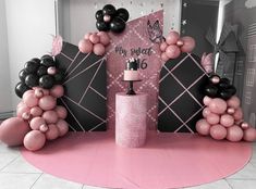 a pink and black birthday party with balloons