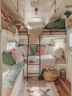 the inside of a small camper with bunk beds and pillows on top of it