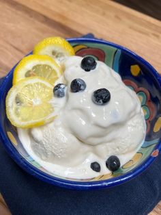 a bowl filled with yogurt, blueberries and lemon slices