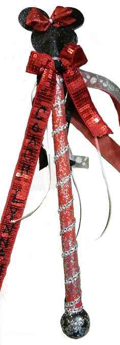 a mickey mouse christmas ornament on top of a pole with a red ribbon