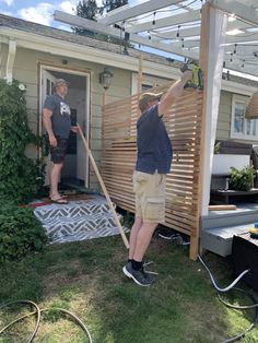 two men working on the outside of a house