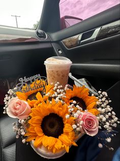 sunflowers and roses in a vase on the back seat of a car