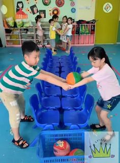 two young children playing with plastic balls in a play room