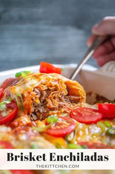 a close up of a plate of enchiladas with tomatoes and green onions