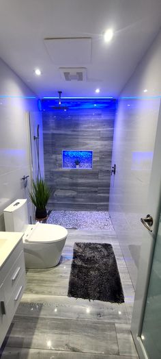 a bathroom with a toilet, sink and bathtub is shown in this image at night