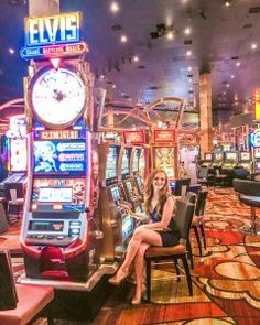 a woman sitting in a chair next to slot machines