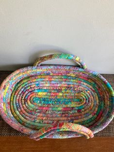 a multicolored basket sitting on top of a wooden table