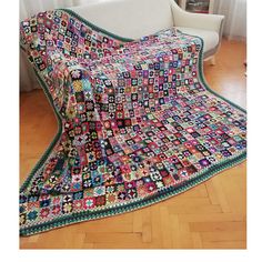 a couch covered in a multicolored afghan