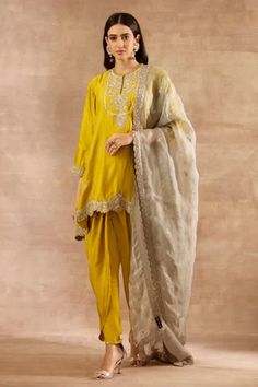 Mustard short tunic with floral zardozi embroidery on yoke and borders. Paired with dhoti pant and mint green organza dupatta.
Component: 3
Pattern: Embroidered
Type Of Work: Zardozi
Neckline: Round
Sleeve Type: Three Quarter
Fabric: Silk, Organza
Color: Yellow
Other Details: 
Scalloped hem kurta and dupatta
Embroidered border dupatta with buttis scattered
Occasion: Mehendi and Haldi - Aza Fashions Tulip Pants, Mehendi Outfit, Haldi Outfits, Jayanti Reddy, Satin Suit, Short Tunic, Zardozi Embroidery, Yellow Suit, Dhoti Pants