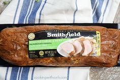 a loaf of meat sitting on top of a blue and white striped towel with the label smothyfield