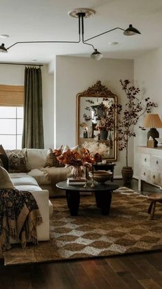 a living room filled with furniture and a large mirror on the wall over a coffee table