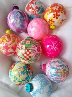 a bunch of colorful ornaments sitting on top of a white sheet