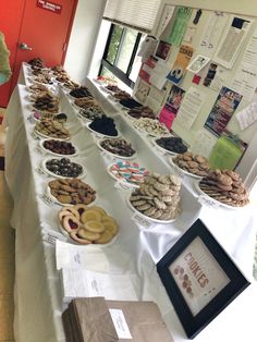 a long table filled with lots of pastries on top of a white table cloth