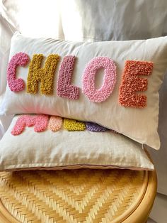 two pillows that have the word pillow on top of each other, one with letters in different colors