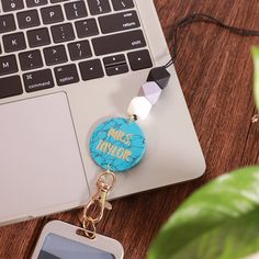 a keychain with the words nice thing on it sitting next to a laptop