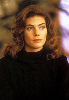 a woman with long hair wearing a black turtle neck sweater and looking off to the side