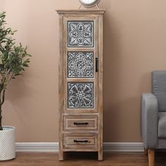 a tall wooden cabinet sitting next to a chair and potted plant on top of a hard wood floor