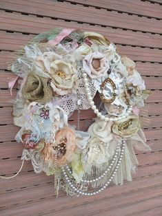 a close up of a wreath with flowers and pearls on the front door handle,