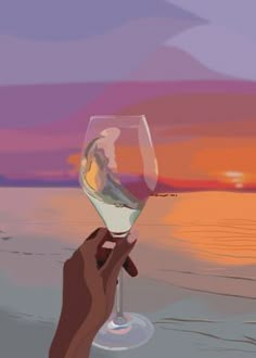 a hand holding a wine glass in front of the ocean at sunset or sunrise,