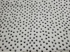 black and white dog paw prints on a white fabric with small dots in the center