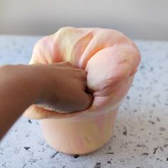 an apple being held up by a person's hand on top of a table