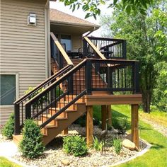 a wooden deck with stairs next to a house