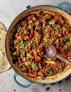 a large pot filled with food next to some pita bread