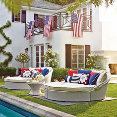 an outdoor living area with couches, tables and american flags