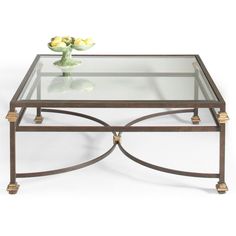 a glass and metal coffee table with yellow flowers on the top, against a white background