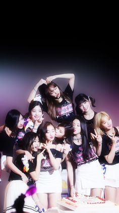 a group of young women standing next to each other in front of a table with a cake on it