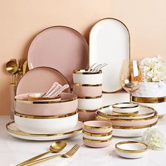 a table topped with plates and bowls covered in gold rims