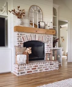 a living room with a brick fireplace and white walls