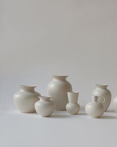 a group of white vases sitting next to each other