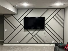 a flat screen tv mounted to the side of a wall in an empty living room