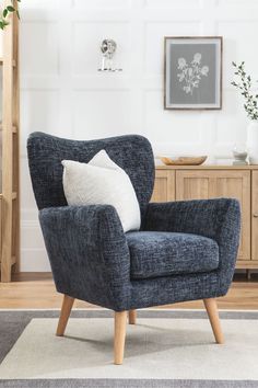 a blue chair sitting on top of a white rug