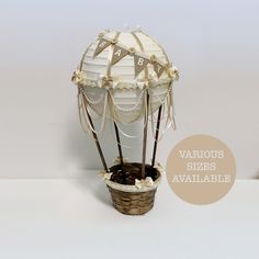 a small white balloon with strings attached to it's sides, sitting in a basket