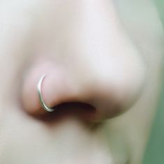 a close up of a nose with a ring on it