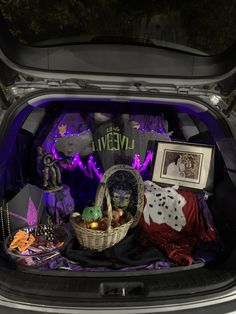 the trunk of a car is filled with halloween decorations and other things to decorate it