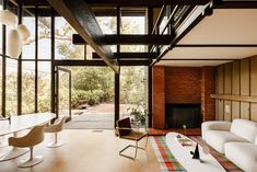 a living room with white furniture and large windows