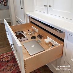 an open laptop computer sitting on top of a wooden desk next to a phone charger