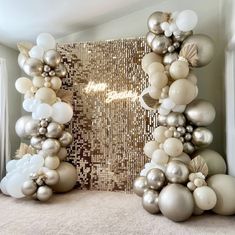 balloons are arranged in the shape of an arch with gold, silver and white decorations