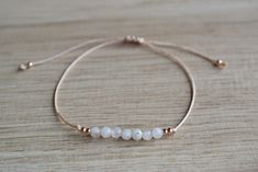 Natural moonstone string bracelet; simple string wish bracelet - Minimalist string bracelet with adjustable sliding closure. - Dainty rose gold plated stainless steel beads. - 4 mm round faceted tiny white moonstone beads. - Beige strong string. - A string bracelet is a symbolic gift to be offered to anyone, as a lucky charm bracelet - Ready to give it as a gift this bracelet comes wrapped in one nice jewelry bag. If you have any questions about this item please feel free to leave a message. If Delicate Adjustable Bracelet With Faceted Beads, Adjustable Dainty Moonstone Jewelry, Dainty Adjustable Moonstone Beaded Bracelet, Dainty Moonstone Beaded Bracelet With Adjustable Fit, Dainty Moonstone Beaded Bracelets Adjustable, Dainty Moonstone Beaded Bracelet Adjustable, Dainty White Jewelry With Sliding Knot, Minimalist Adjustable Rose Gold Bracelet, Minimalist Rose Gold Bracelets With Adjustable Length