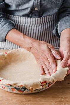 a person is kneading dough into a pie crust