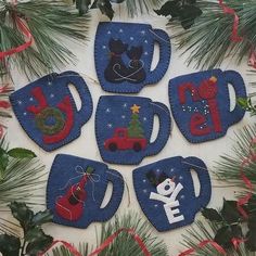 six christmas mugs are hanging on the wall