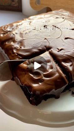 chocolate fudge cake on a white plate with a spoon