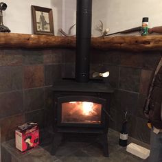 a wood burning stove sitting inside of a living room next to a firewood log