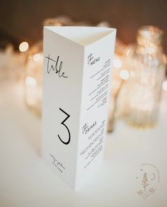 the table numbers are placed on top of each other in front of some lit candles