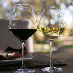 two glasses of wine sitting on top of a table